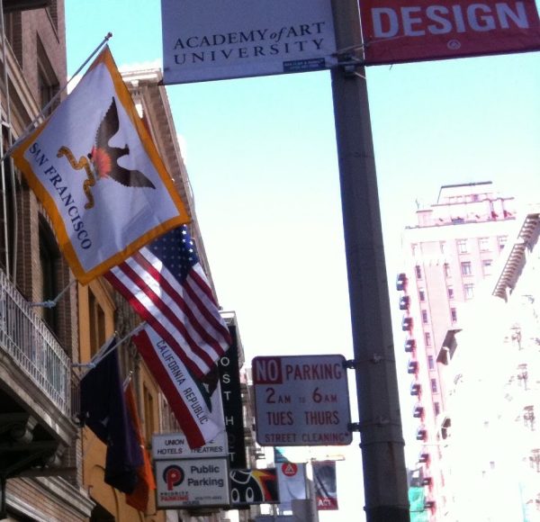 Image of the official San Francisco city flag featuring a brown phoenix rising from orange, red, and yellow flames with the Spanish motto "Oro en Paz. Fierro en Guerra" (Gold in Peace. Iron in War) written in gold below.